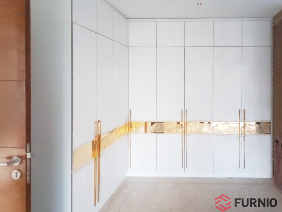 White L-shaped wardrobe with gold accents.