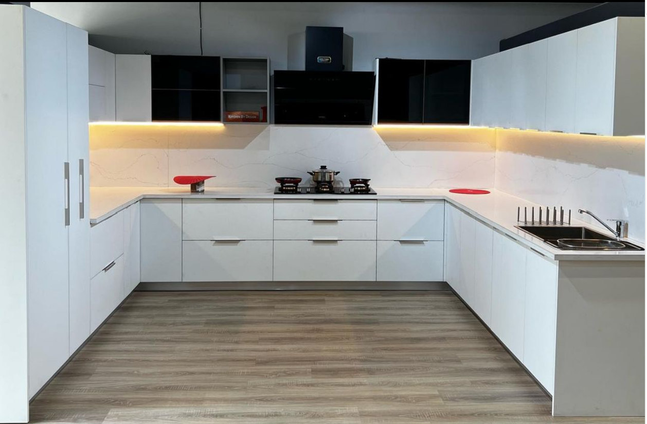 Sleek white kitchen with a gas stove and modern cabinets.