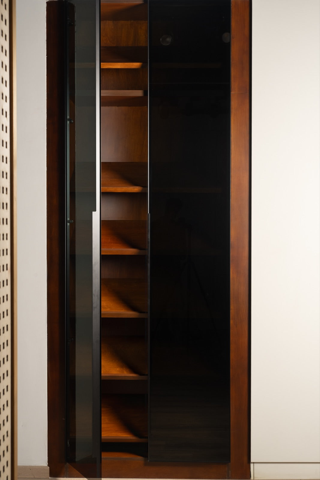 Smoked-glass display · walnut shelving