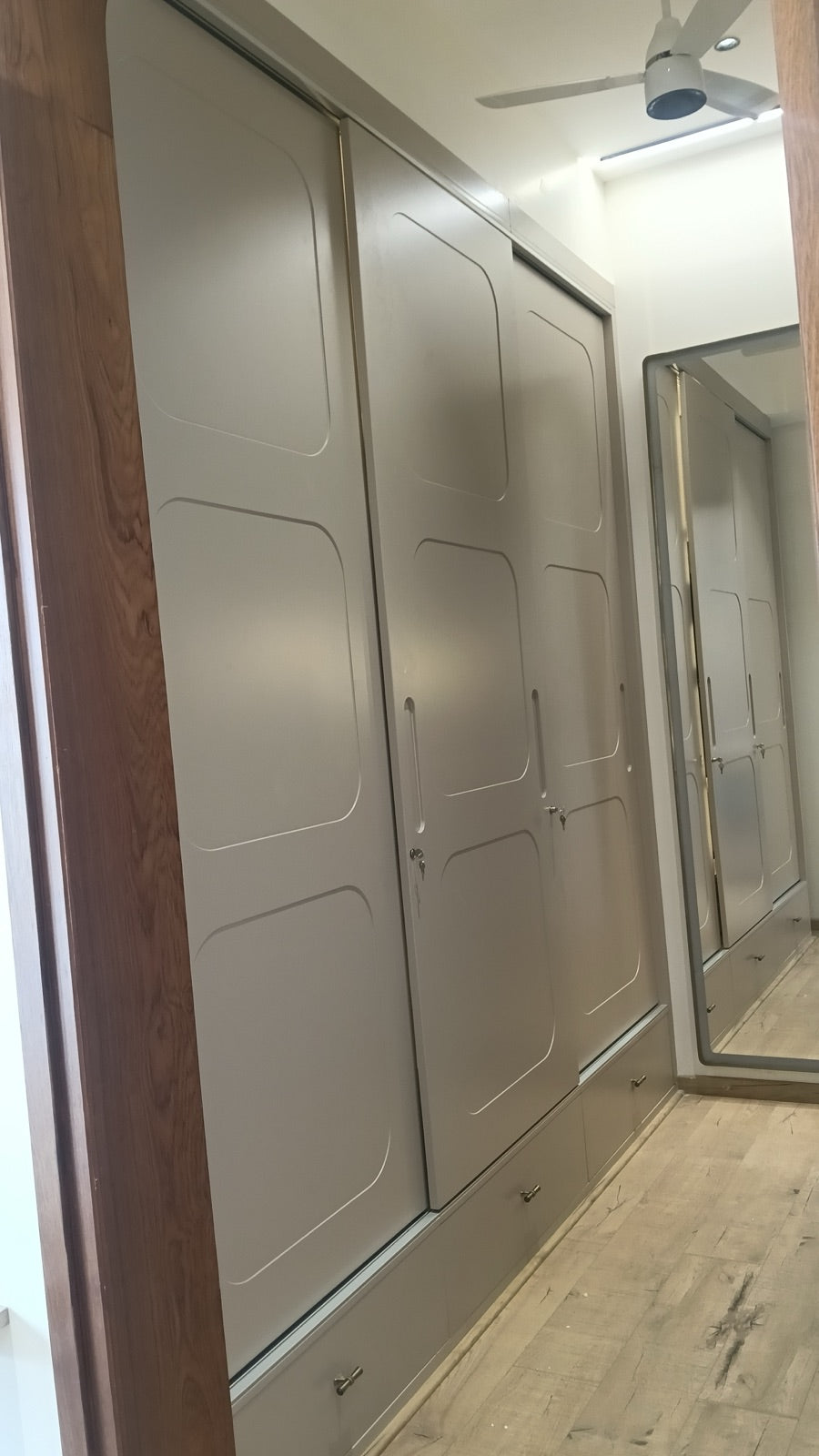 Dressing passage wardrobe · sliding doors next to wood-framed archway