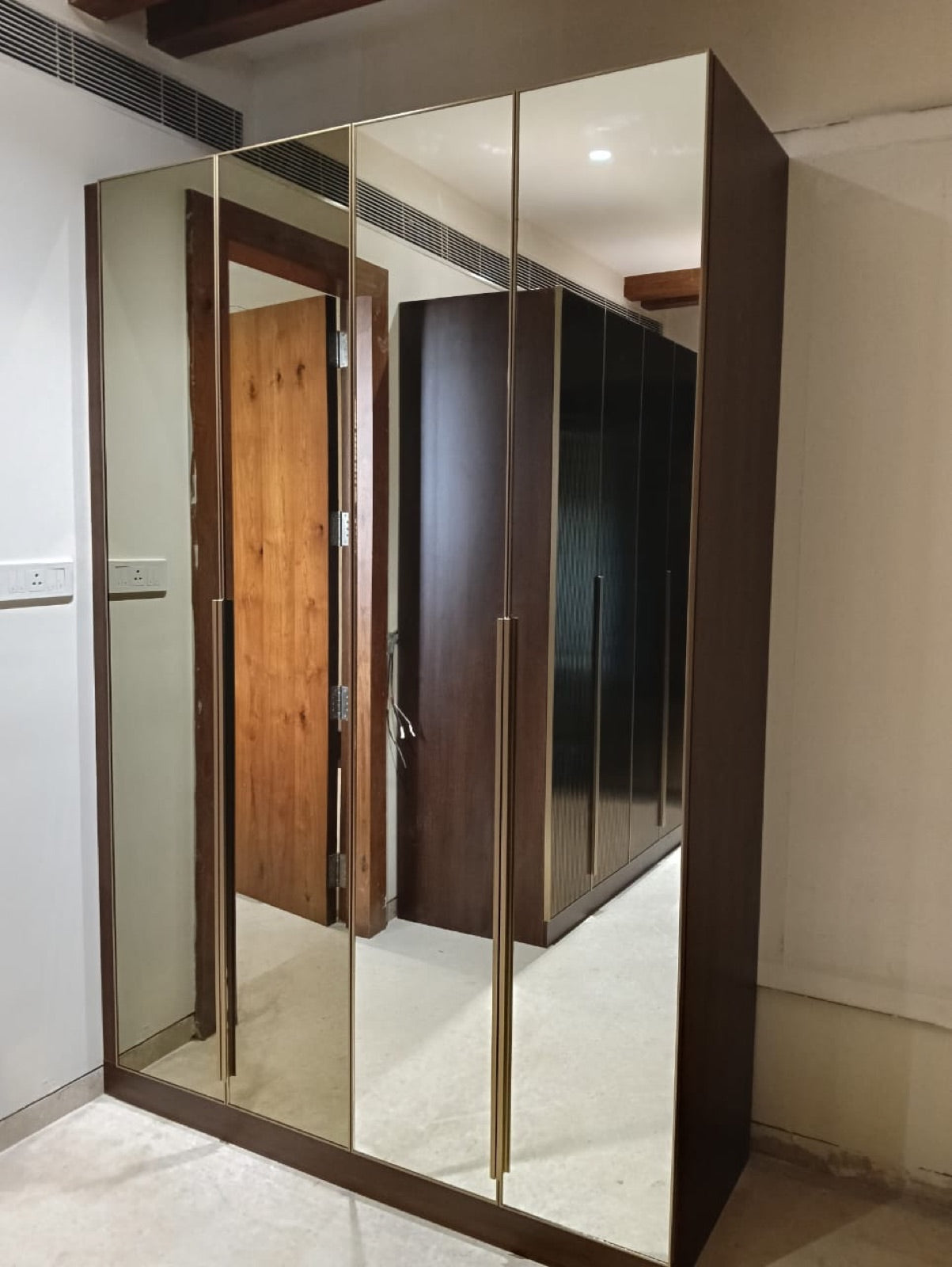 Corner wardrobe · full-height mirror doors with bronze trim