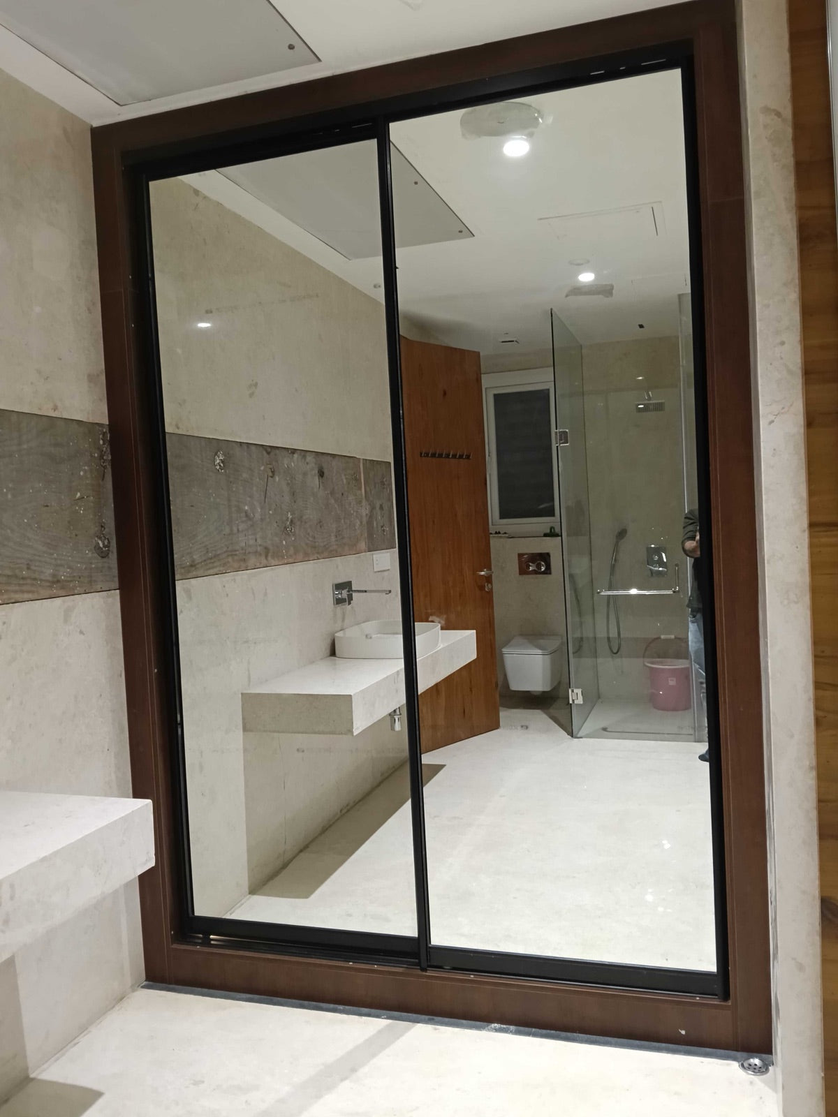 Bathroom mirror sliding door · reflects stone vanity counter and shower